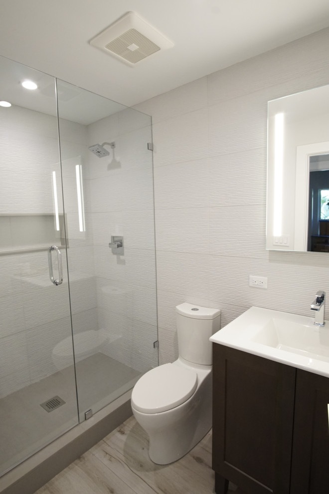 Immagine di una piccola stanza da bagno moderna con ante in stile shaker, ante in legno bruno, piastrelle bianche, piastrelle in gres porcellanato, top bianco, un lavabo e mobile bagno freestanding