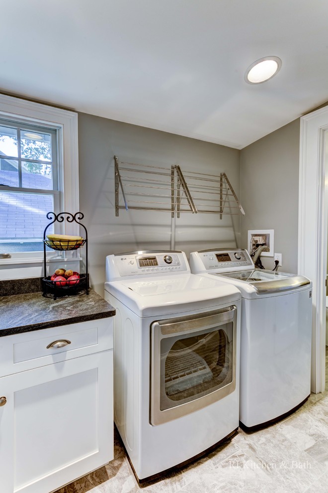 Photo of a mid-sized arts and crafts galley utility room in Providence with shaker cabinets, white cabinets, granite benchtops, grey walls, porcelain floors and a side-by-side washer and dryer.