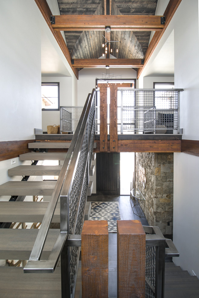 Design ideas for a large industrial wood floating staircase in Denver with open risers and metal railing.