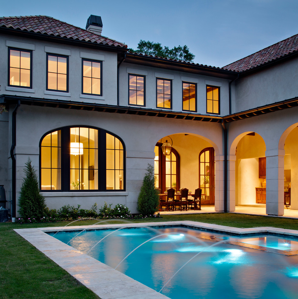 Design ideas for a large mediterranean backyard rectangular pool in Houston with a hot tub and natural stone pavers.
