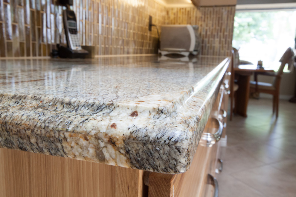Inspiration for a large transitional galley ceramic tile enclosed kitchen remodel in Phoenix with an undermount sink, recessed-panel cabinets, light wood cabinets, granite countertops, brown backsplash, glass tile backsplash and stainless steel appliances