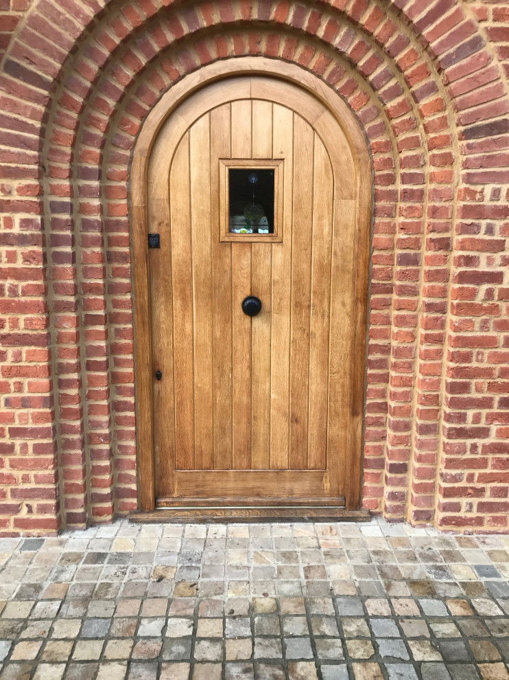Photo of a large country front door in Essex with a light wood front door.