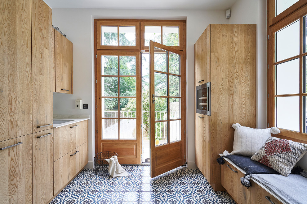 This is an example of a mediterranean entryway in Lyon with white walls, a double front door, a glass front door and multi-coloured floor.