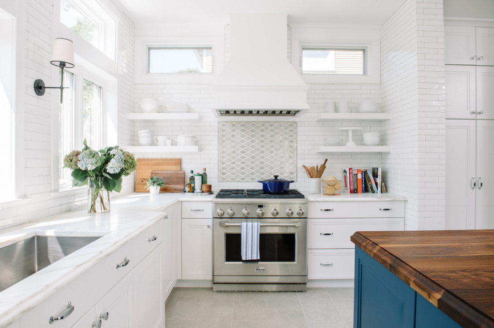 Transitional l-shaped gray floor kitchen photo in DC Metro with an undermount sink, recessed-panel cabinets, white cabinets, white backsplash, subway tile backsplash, stainless steel appliances, an island and white countertops