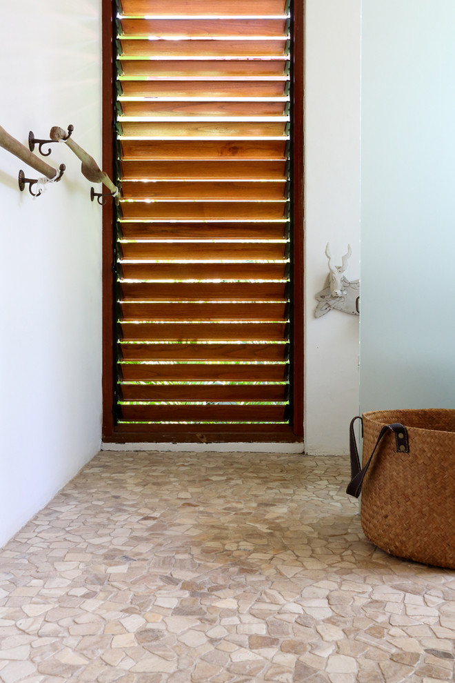 Photo of a tropical bathroom in Other with beige tile, stone tile and beige walls.