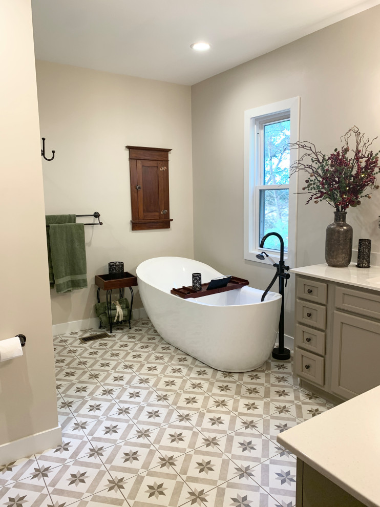 Bild på ett lantligt badrum, med släta luckor, grå skåp, ett fristående badkar, en dusch i en alkov, grå väggar, klinkergolv i keramik, ett integrerad handfat, flerfärgat golv och dusch med gångjärnsdörr