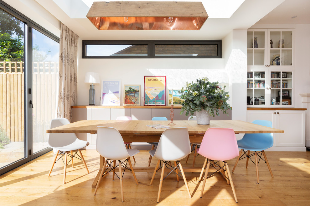 Inspiration for a large contemporary open plan dining in London with white walls and medium hardwood floors.