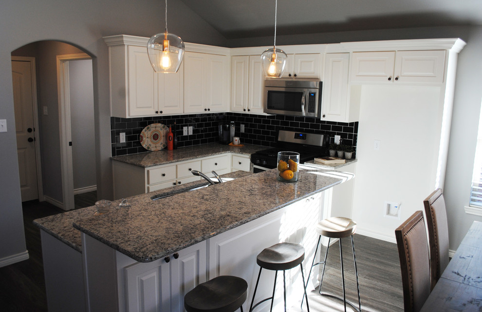 Inspiration for a mid-sized eclectic l-shaped eat-in kitchen in Austin with an undermount sink, recessed-panel cabinets, yellow cabinets, granite benchtops, black splashback, subway tile splashback, stainless steel appliances, vinyl floors and with island.