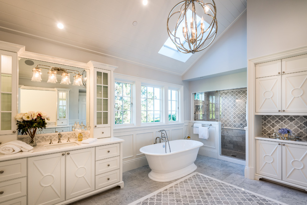 Design ideas for a transitional master bathroom in Los Angeles with white cabinets, a freestanding tub, an alcove shower, gray tile, grey walls, an undermount sink, grey floor, a hinged shower door, white benchtops and beaded inset cabinets.