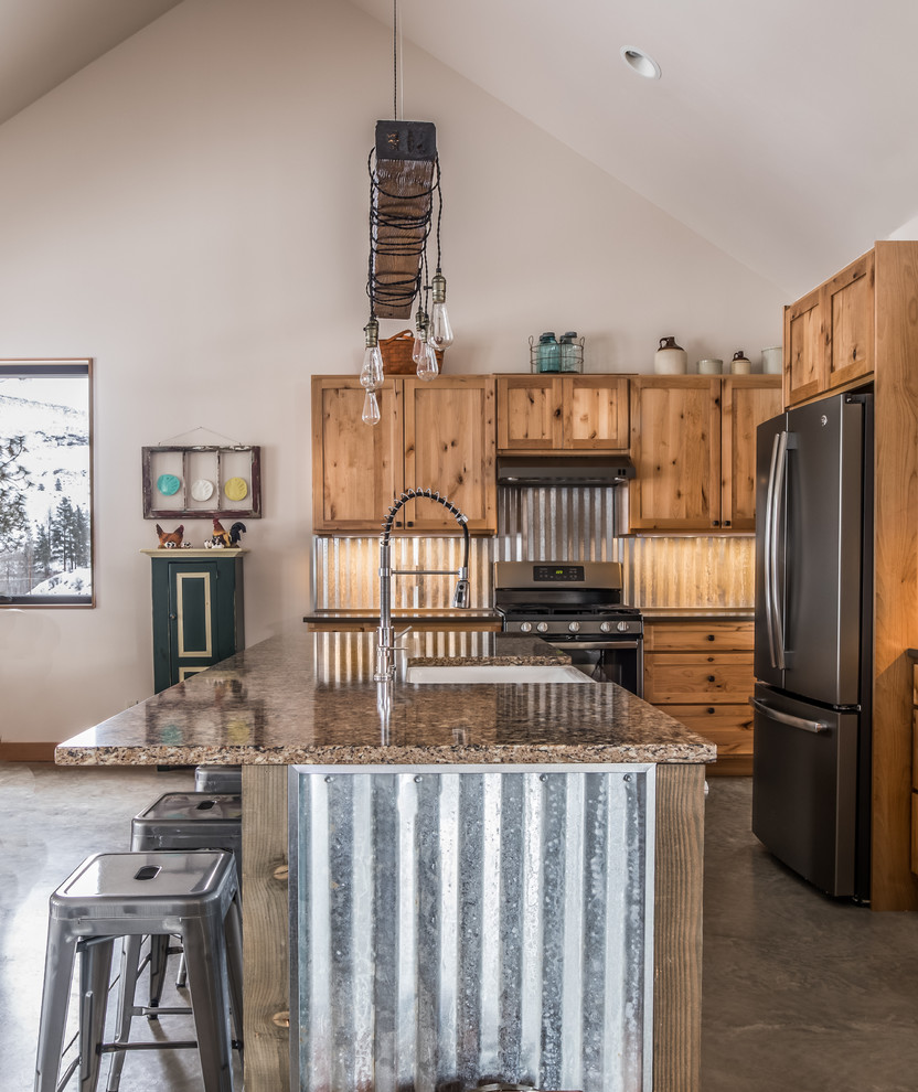 Mid-sized country l-shaped eat-in kitchen in Seattle with shaker cabinets, light wood cabinets, with island, a farmhouse sink, metallic splashback, stainless steel appliances, concrete floors, grey floor, multi-coloured benchtop and granite benchtops.