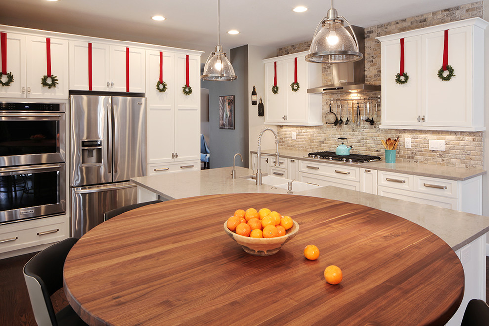 Kitchen - large transitional dark wood floor kitchen idea in Denver with a farmhouse sink, flat-panel cabinets, white cabinets, quartzite countertops, beige backsplash, stone tile backsplash, stainless steel appliances and an island