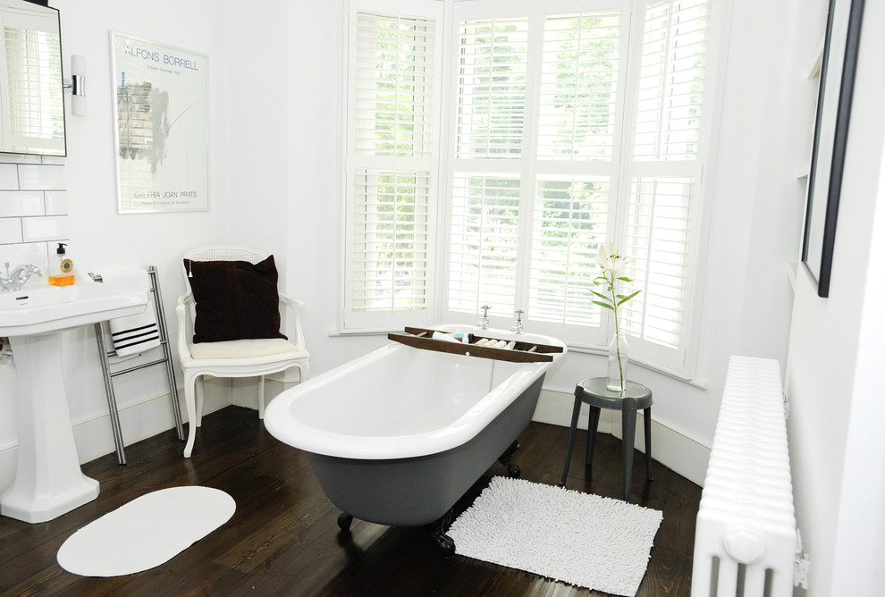 Photo of a contemporary bathroom in London with a freestanding tub and dark hardwood floors.