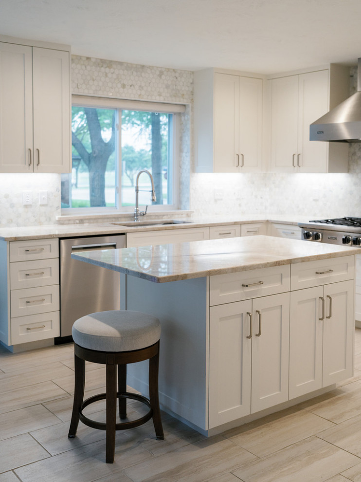 Large transitional u-shaped medium tone wood floor and brown floor enclosed kitchen photo in Dallas with an undermount sink, raised-panel cabinets, beige cabinets, quartzite countertops, white backsplash, marble backsplash, stainless steel appliances, an island and beige countertops