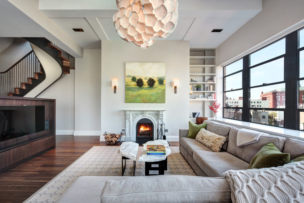 Design ideas for a transitional formal living room in New York with beige walls, dark hardwood floors, a standard fireplace and a wall-mounted tv.