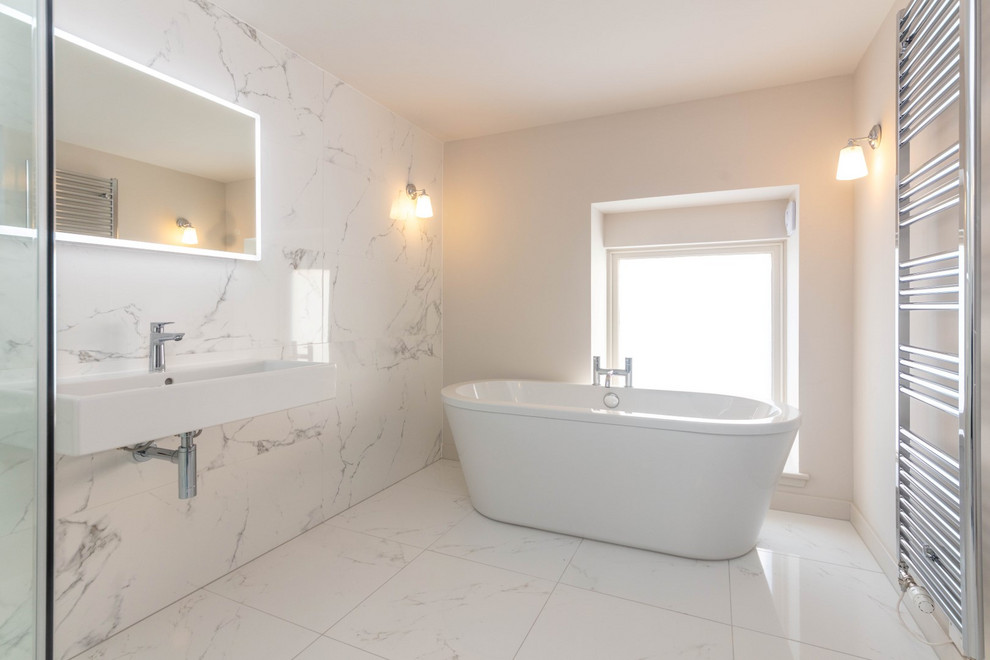 Design ideas for a contemporary master bathroom in Glasgow with a freestanding tub, a wall-mount toilet, white tile, white walls, porcelain floors and a wall-mount sink.