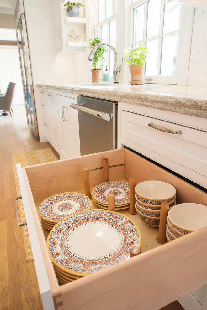 Design ideas for a large traditional galley open plan kitchen in Other with an undermount sink, beaded inset cabinets, white cabinets, quartzite benchtops, white splashback, subway tile splashback, stainless steel appliances, light hardwood floors and a peninsula.