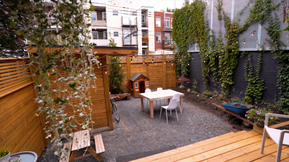 Small arts and crafts backyard and ground level deck in Chicago with with privacy feature.
