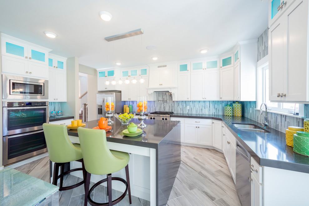 Large transitional u-shaped eat-in kitchen in Salt Lake City with a double-bowl sink, shaker cabinets, white cabinets, grey splashback, matchstick tile splashback, stainless steel appliances, with island, solid surface benchtops and ceramic floors.