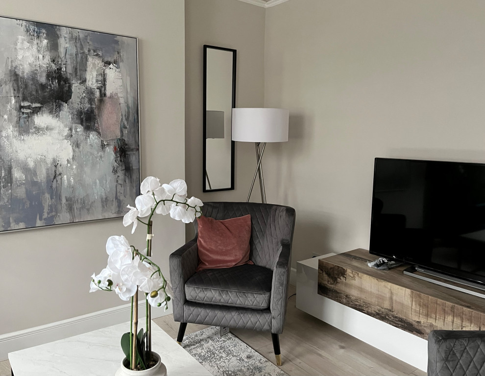 Design ideas for a medium sized contemporary grey and black living room in London with beige walls, medium hardwood flooring and a freestanding tv.