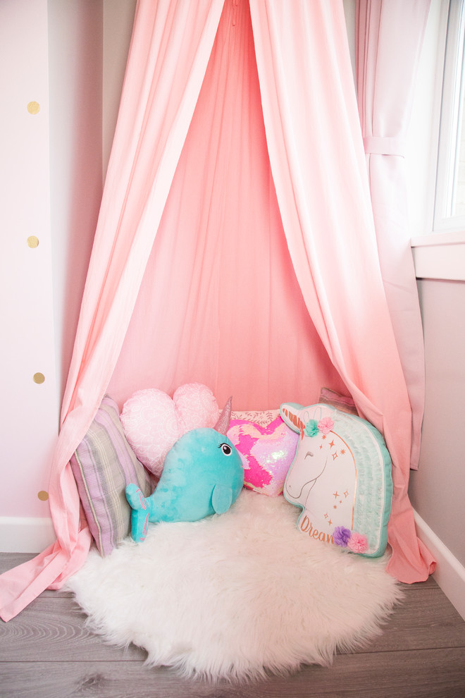 Photo of a mid-sized contemporary kids' room for girls in Edinburgh with pink walls and laminate floors.