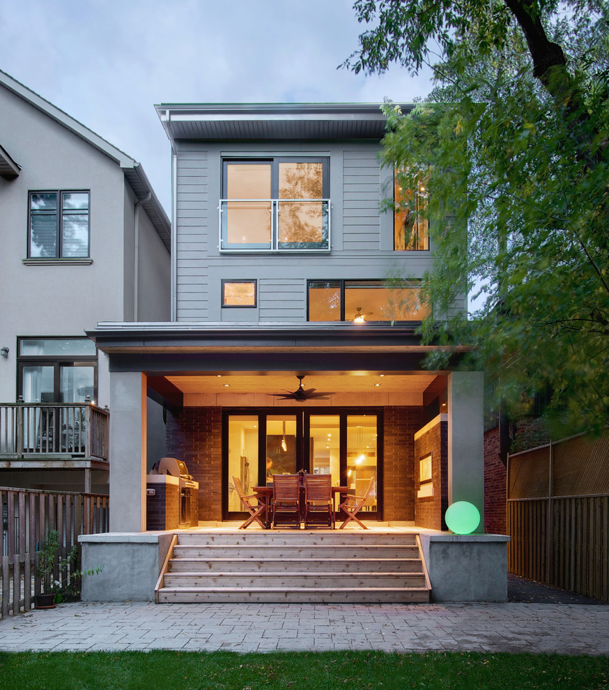 Photo of a small contemporary three-storey brick black exterior in Toronto with a flat roof.