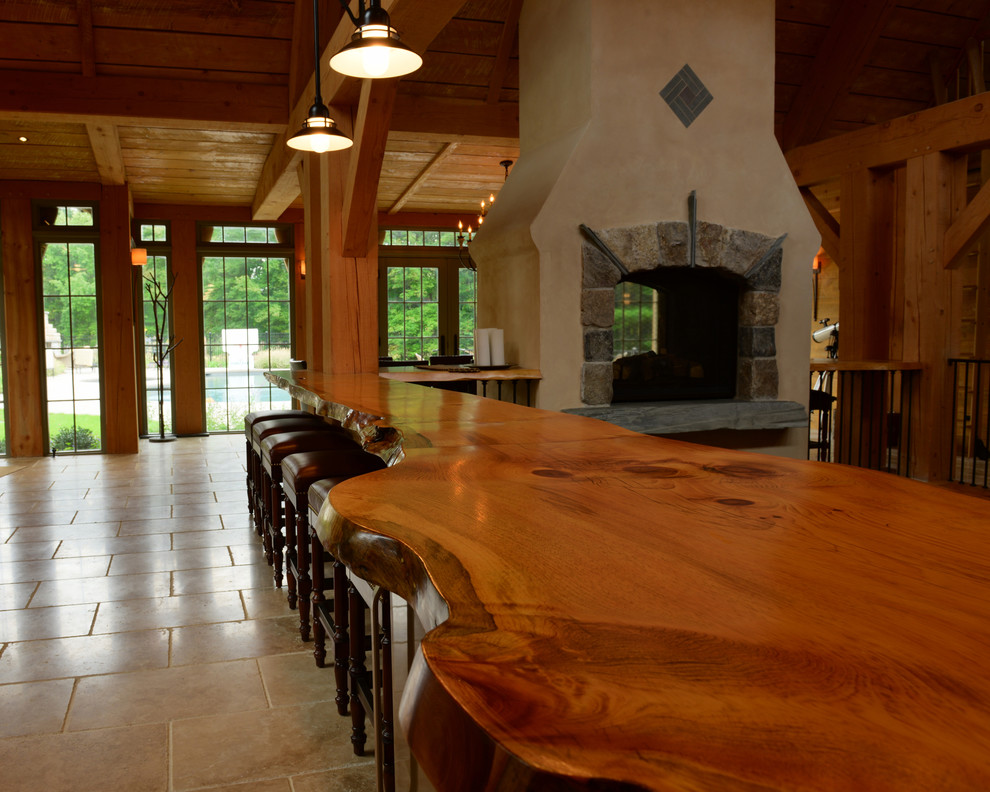 Country dining room in Boston with a two-sided fireplace and a stone fireplace surround.