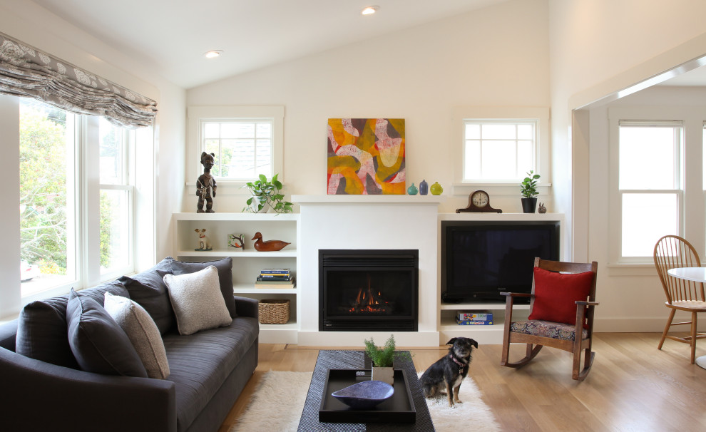 Living room - transitional open concept light wood floor, beige floor and vaulted ceiling living room idea in San Francisco with a plaster fireplace, white walls and a standard fireplace