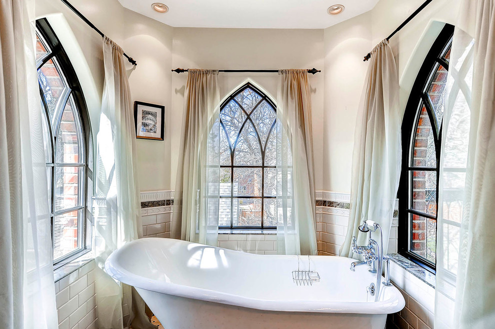 This is an example of a traditional master bathroom in Denver with a freestanding tub and beige walls.