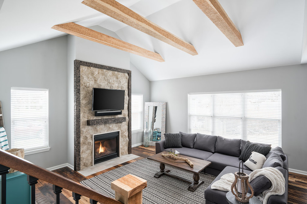 This is an example of an expansive traditional open concept family room in Columbus with grey walls, medium hardwood floors, a standard fireplace, a tile fireplace surround, a wall-mounted tv and multi-coloured floor.