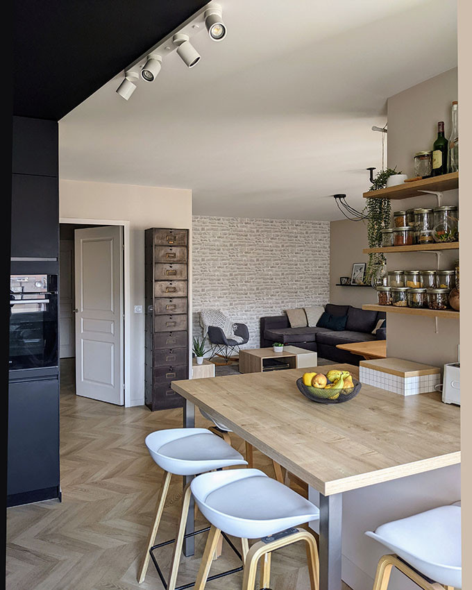 Esempio di una cucina minimal di medie dimensioni con lavello a vasca singola, ante nere, top in legno, paraspruzzi in legno, elettrodomestici neri e parquet chiaro