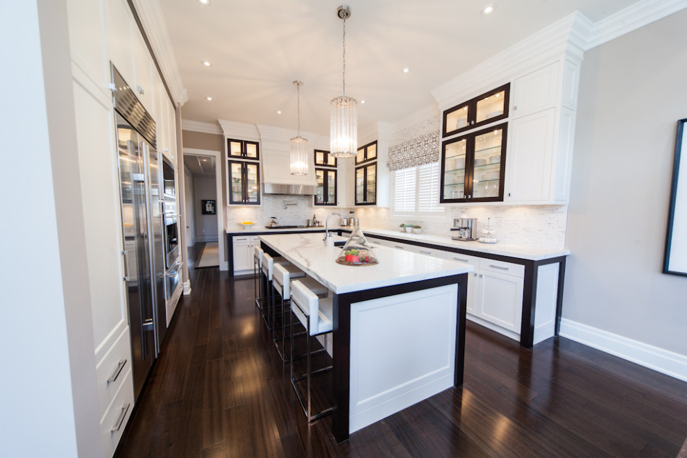 Example of a mid-sized transitional l-shaped dark wood floor and brown floor kitchen design in Toronto with an undermount sink, shaker cabinets, white cabinets, quartz countertops, multicolored backsplash, quartz backsplash, stainless steel appliances, an island and multicolored countertops