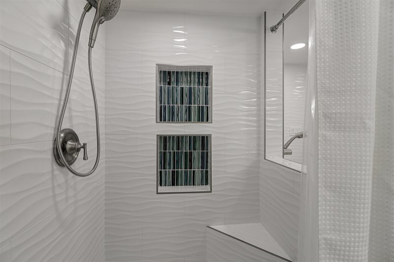 На фото: главная ванная комната среднего размера в морском стиле с фасадами в стиле шейкер, белыми фасадами, отдельно стоящей ванной, открытым душем, унитазом-моноблоком, белой плиткой, керамической плиткой, синими стенами, полом из керамогранита, врезной раковиной, столешницей из кварцита, серым полом, шторкой для ванной, бежевой столешницей, тумбой под одну раковину, встроенной тумбой и сиденьем для душа с