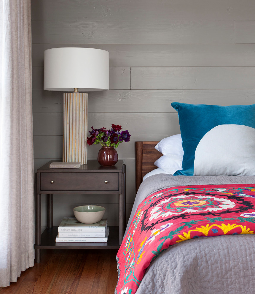 Stilmix Schlafzimmer mit grauer Wandfarbe, dunklem Holzboden, braunem Boden und Holzdielenwänden in Austin