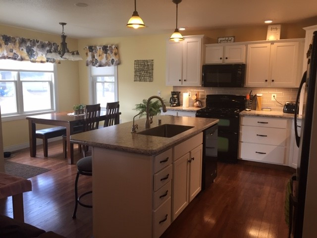 Inspiration for a mid-sized transitional l-shaped eat-in kitchen remodel with shaker cabinets, white cabinets and an island