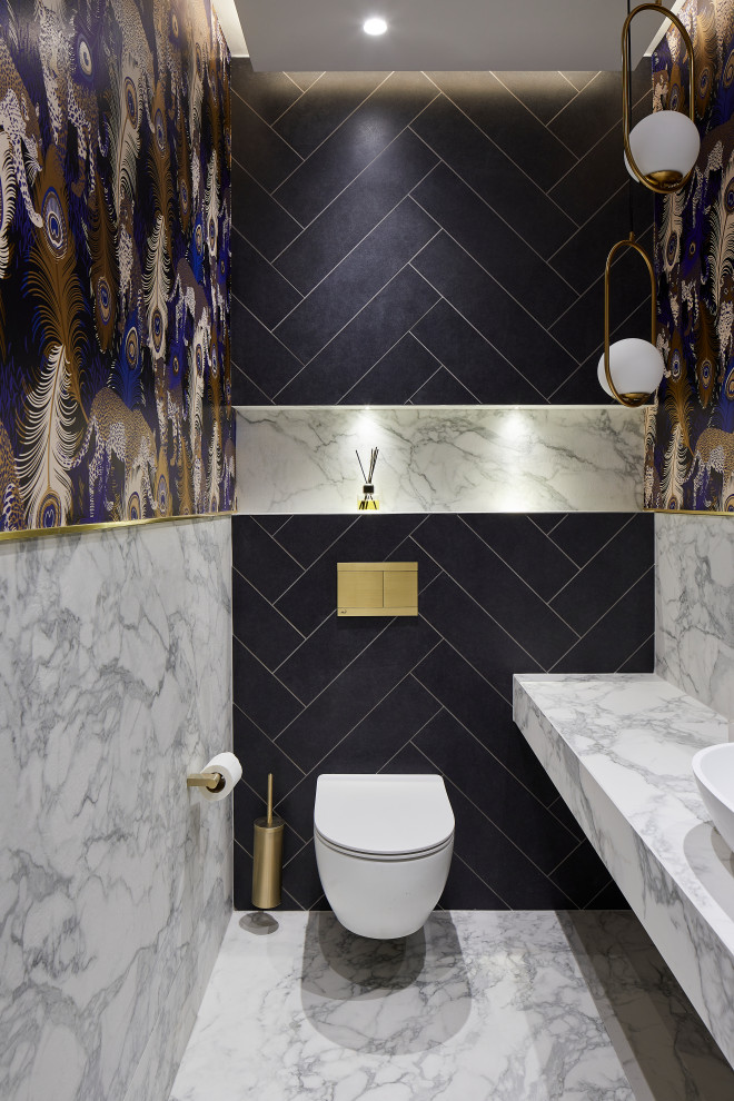 This is an example of a small contemporary cloakroom in London with a wall mounted toilet, blue tiles, a console sink, marble worktops and white worktops.