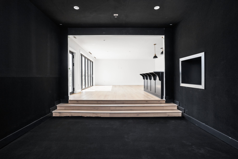 Modelo de sótano con puerta Cuarto de juegos clásico renovado grande sin cuartos de juegos con paredes negras, moqueta y suelo negro