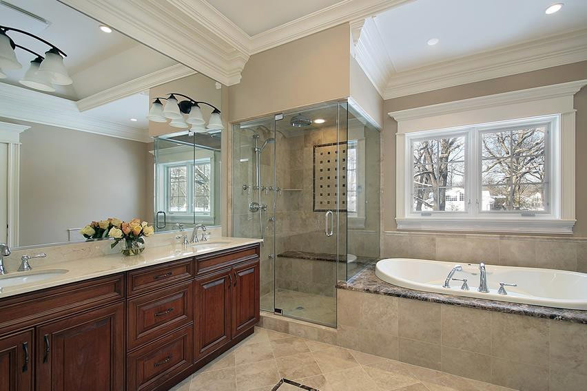 This is an example of a mid-sized traditional master bathroom in Other with raised-panel cabinets, dark wood cabinets, a drop-in tub, a corner shower, beige tile, travertine, beige walls, travertine floors, a drop-in sink, engineered quartz benchtops, beige floor, a hinged shower door and beige benchtops.