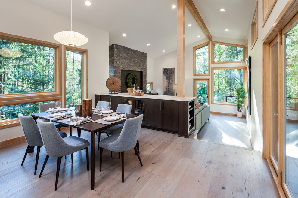 Photo of a midcentury open plan dining in Portland with white walls, light hardwood floors and no fireplace.