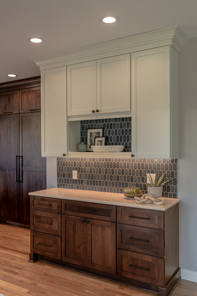 Inspiration for a mid-sized transitional l-shaped medium tone wood floor and brown floor eat-in kitchen remodel with an undermount sink, recessed-panel cabinets, dark wood cabinets, quartz countertops, blue backsplash, mosaic tile backsplash, stainless steel appliances, an island and white countertops