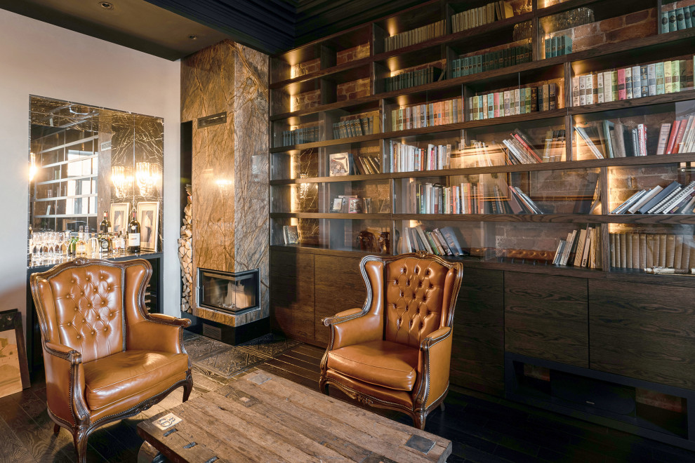 サンクトペテルブルクにある高級な中くらいなインダストリアルスタイルのおしゃれな書斎 (濃色無垢フローリング、コーナー設置型暖炉、石材の暖炉まわり、造り付け机、レンガ壁) の写真
