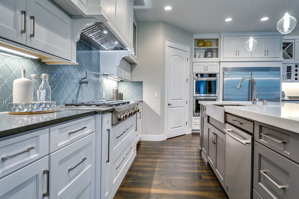 Large transitional l-shaped eat-in kitchen in Portland with shaker cabinets, grey cabinets, quartzite benchtops, grey splashback, glass tile splashback, stainless steel appliances, dark hardwood floors, with island and brown floor.