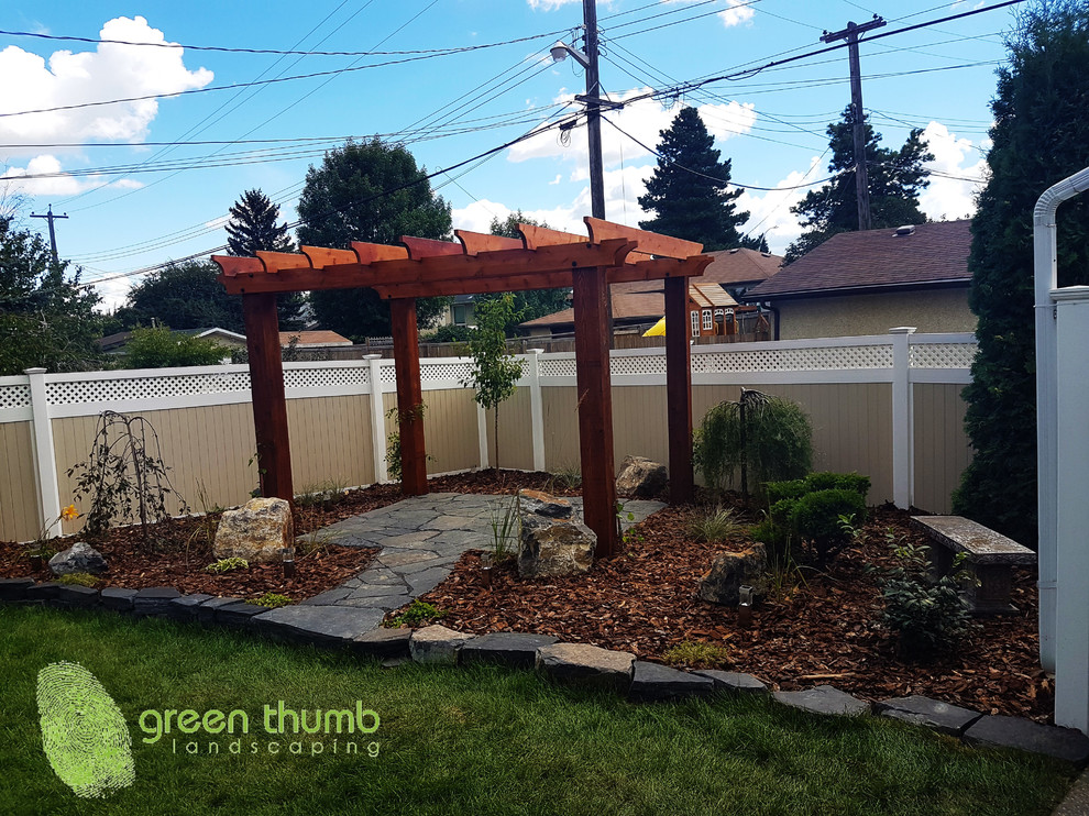 Inspiration for a rustic full sun backyard stone retaining wall landscape in Edmonton for summer.