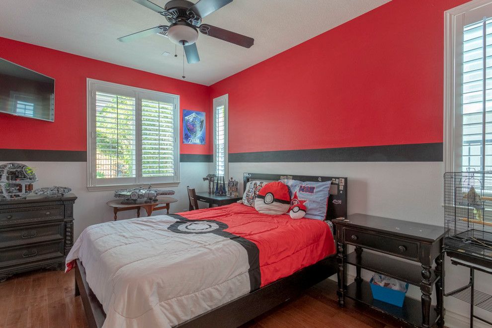 This is an example of a mid-sized transitional guest bedroom in Los Angeles with red walls, medium hardwood floors and brown floor.