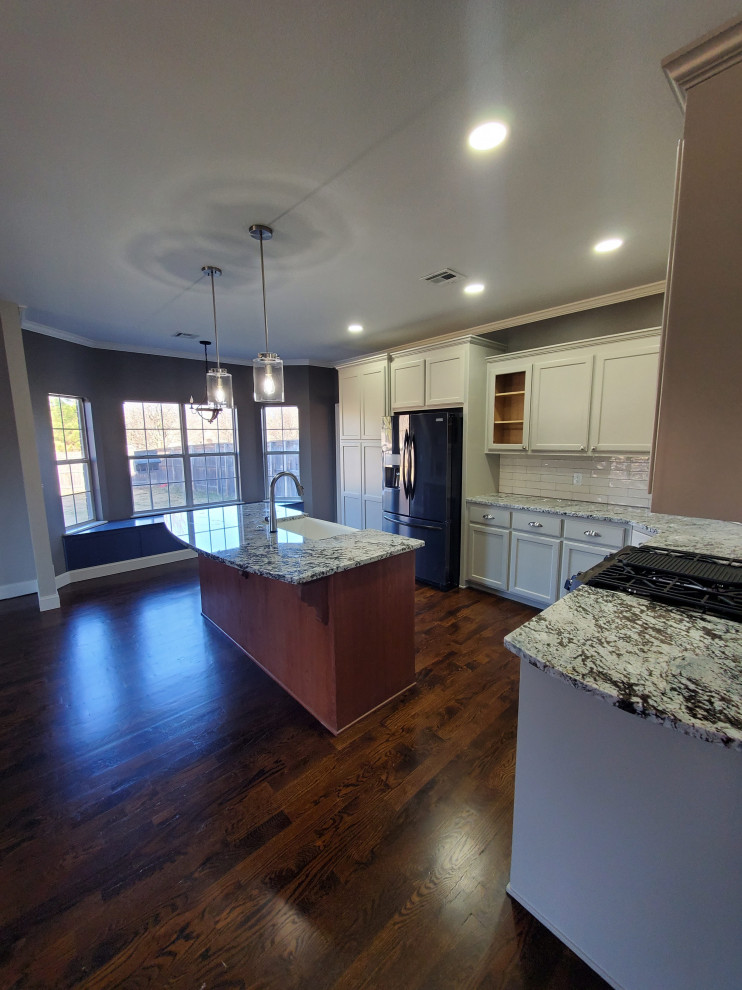 Exempel på ett mellanstort modernt flerfärgad flerfärgat kök, med en rustik diskho, luckor med profilerade fronter, vita skåp, granitbänkskiva, vitt stänkskydd, stänkskydd i glaskakel, rostfria vitvaror, mörkt trägolv, en köksö och brunt golv