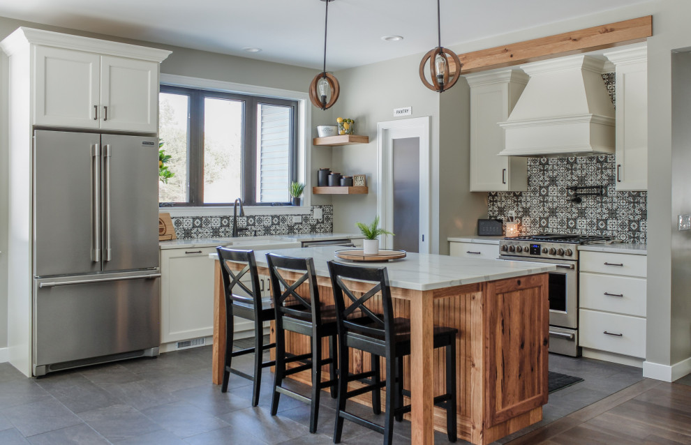 Design ideas for a small country l-shaped kitchen in Detroit with a farmhouse sink, flat-panel cabinets, white cabinets, quartz benchtops, grey splashback, stainless steel appliances, medium hardwood floors, with island, brown floor and grey benchtop.