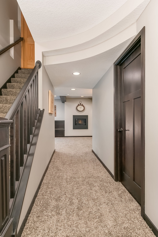 Design ideas for a large transitional walk-out basement in Minneapolis with carpet, grey walls, a ribbon fireplace, a metal fireplace surround and beige floor.