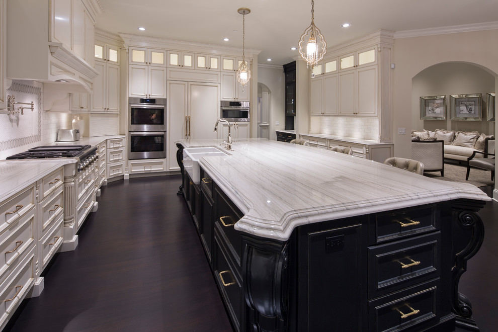 Photo of an u-shaped separate kitchen in Chicago with a farmhouse sink, shaker cabinets, black cabinets, white splashback, ceramic splashback, stainless steel appliances, dark hardwood floors, with island, black floor and white benchtop.