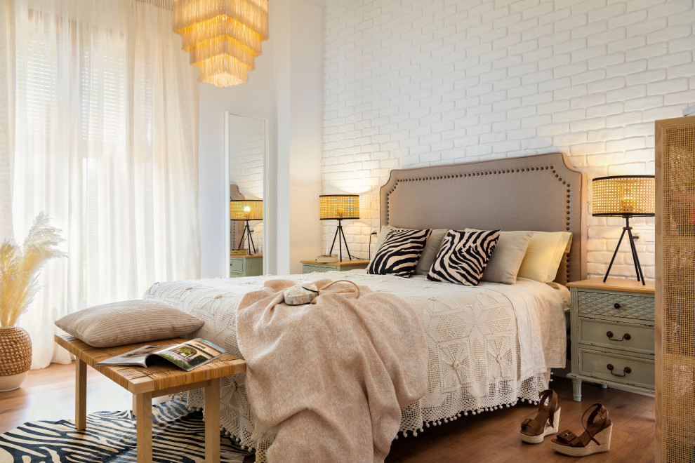 Inspiration for a contemporary bedroom in Seville with white walls, medium hardwood floors, brown floor and brick walls.
