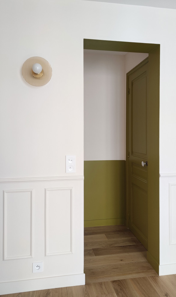 Ejemplo de distribuidor minimalista de tamaño medio con paredes verdes, suelo de madera clara, puerta simple, puerta verde y suelo marrón