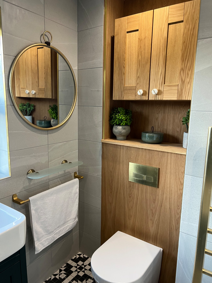 This is an example of a small modern kids bathroom in London with raised-panel cabinets, a drop-in tub, a shower/bathtub combo, green walls, mosaic tile floors, a drop-in sink, a single vanity and a built-in vanity.